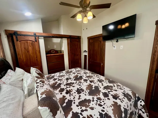 a bedroom with a bed and a flat screen tv