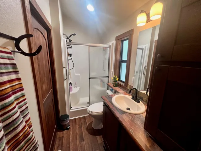 a bathroom with a granite countertop sink toilet and shower a mirror