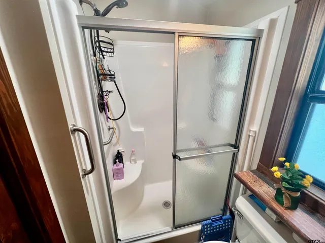 a bathroom with a shower and a mirror