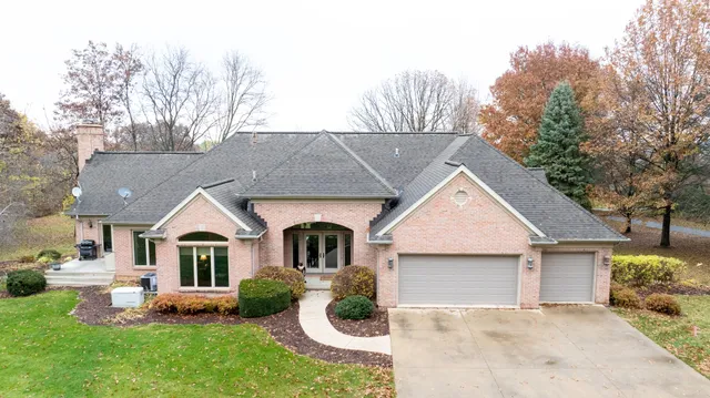 an aerial view of a house with swimming pool big yard and large trees