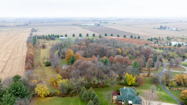 an aerial view of a house with a yard and a large tree