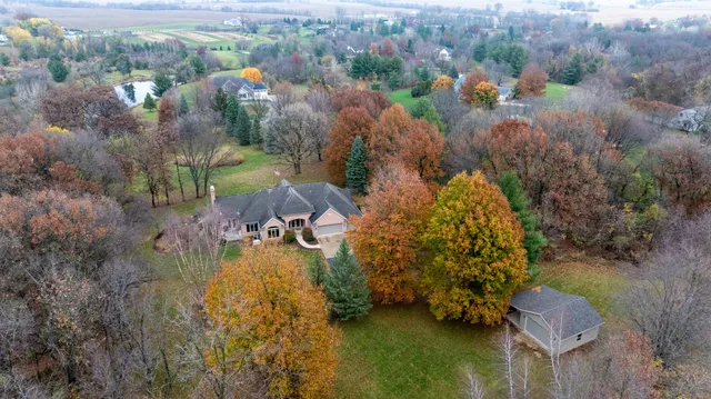 a kitchen with stainless steel appliances kitchen island granite countertop a table chairs sink and cabinets