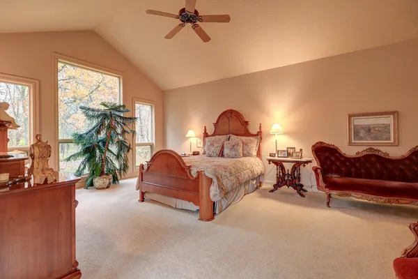 a living room with couches and kitchen view with wooden floor