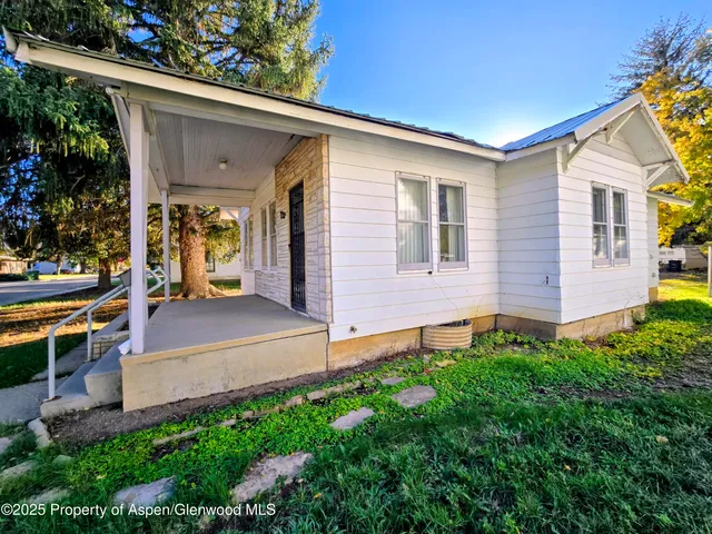 a view of a house with backyard and sitting area