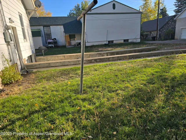 a white house that has tree in front of it