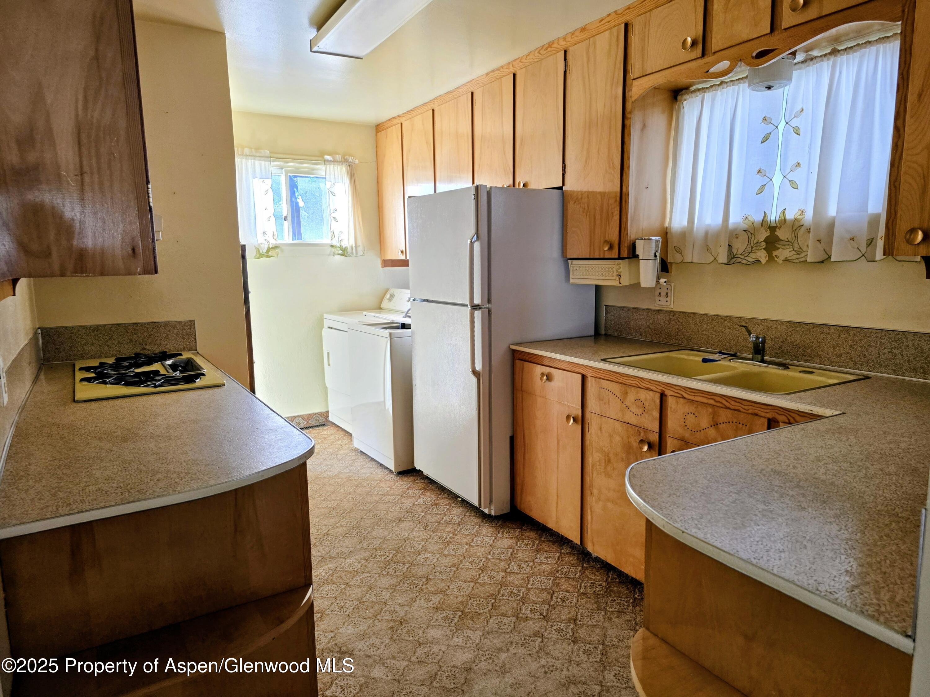 720 Barclay Street Craig, CO 81625 - Photo 7 of 22 a kitchen with stainless steel appliances granite countertop a stove a refrigerator a sink dishwasher and wooden cabinets with a granite countertops