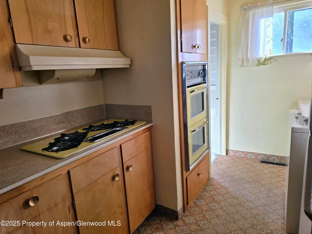 a kitchen with stainless steel appliances granite countertop a refrigerator a washer and dryer