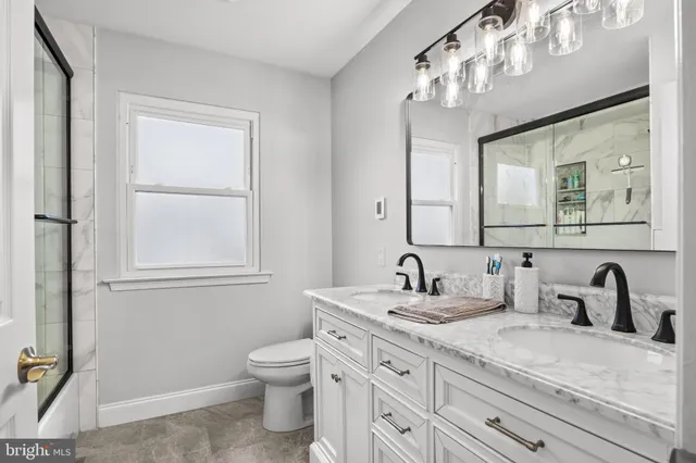 a bathroom with a glass shower door and a window
