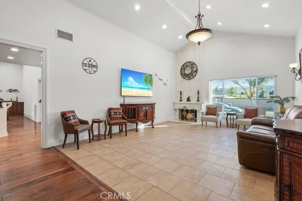 a view of a livingroom with furniture a fireplace windows and wooden floor