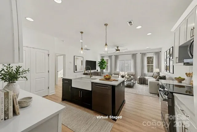 a living room with furniture and a view of kitchen