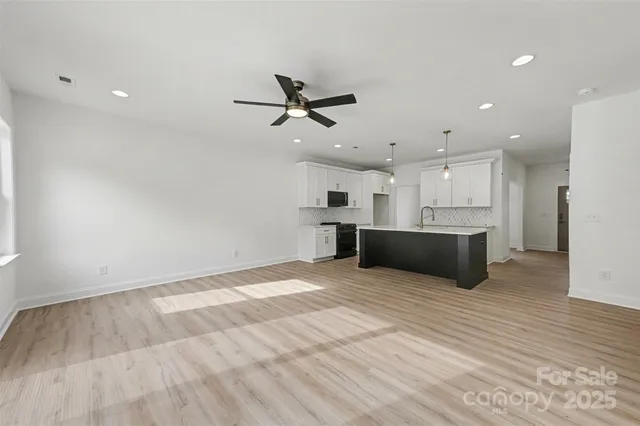 a view of a room with wooden floor windows and a chandelier