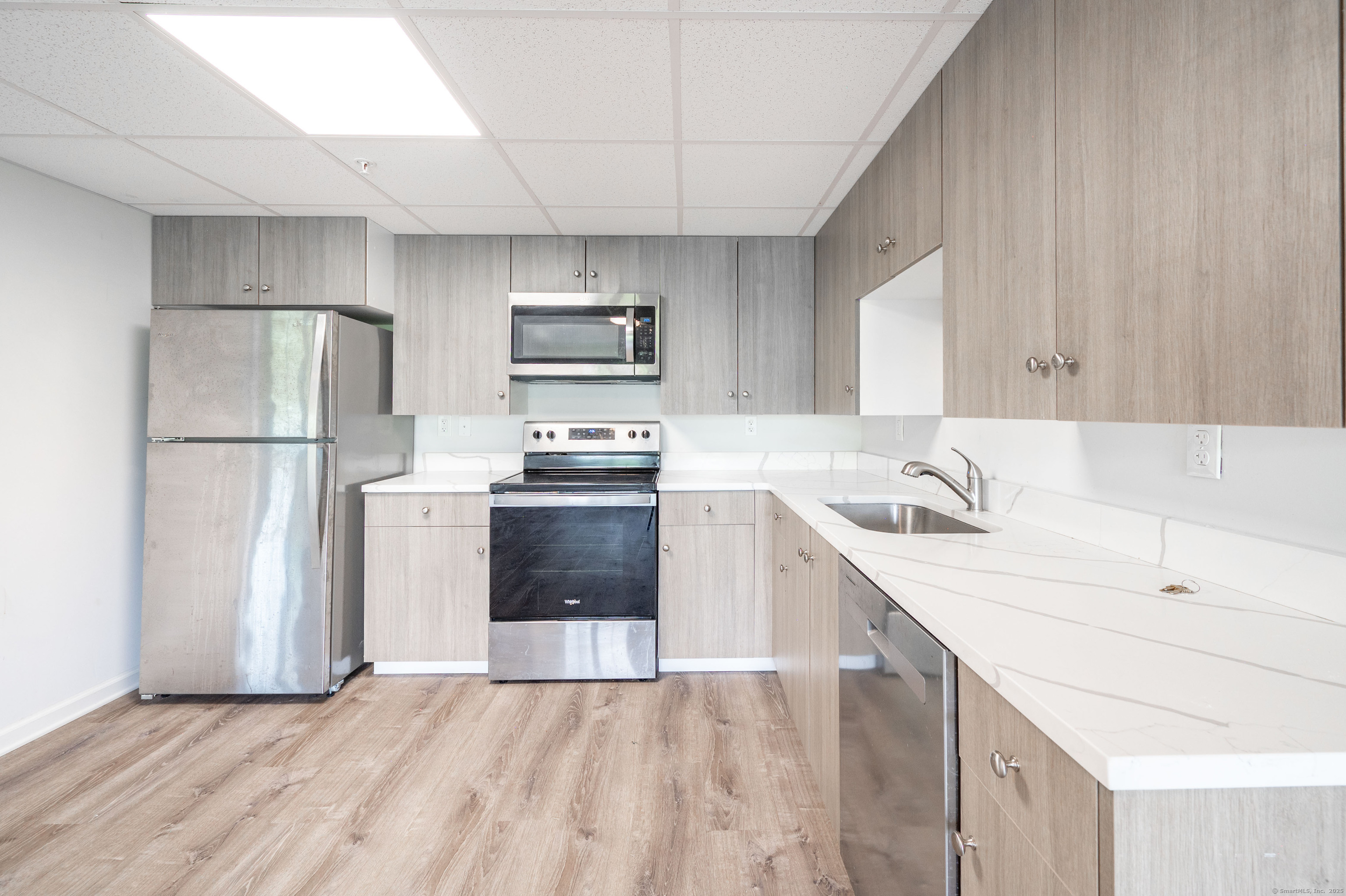 1030 Federal Road, Unit 201 Brookfield, CT 06804 - Photo 9 of 20 a kitchen with a sink a refrigerator and a stove