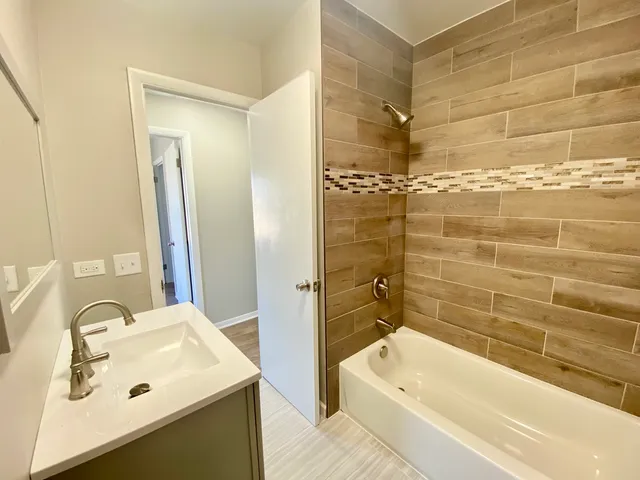 a bathroom with a sink tub shower and a mirror