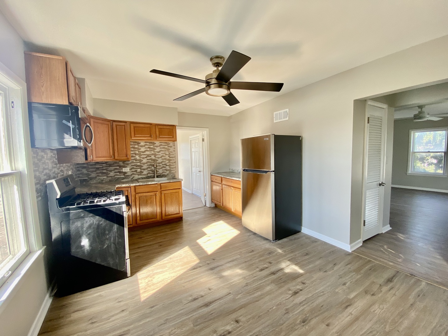 5543 West Margaret Street, Unit B Monee, IL 60449 - Photo 4 of 11 a kitchen with stainless steel appliances granite countertop a refrigerator a stove and a wooden floors