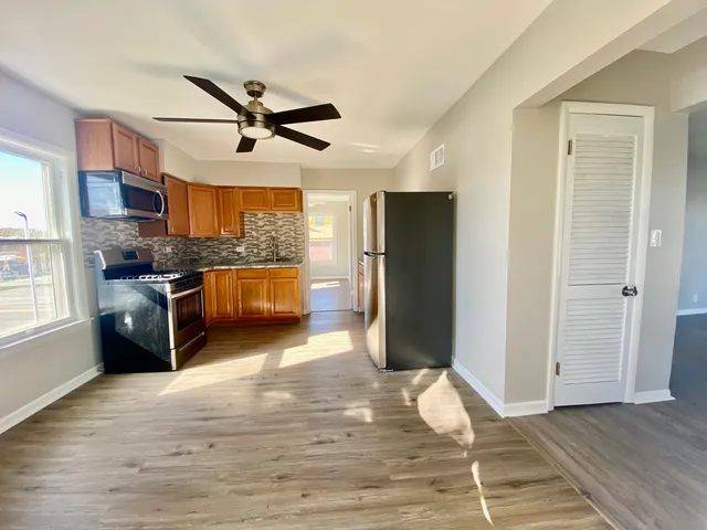 a kitchen with stainless steel appliances granite countertop a refrigerator a stove a sink and a microwave