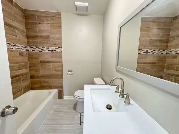 a bathroom with a sink mirror vanity shower and bathtub