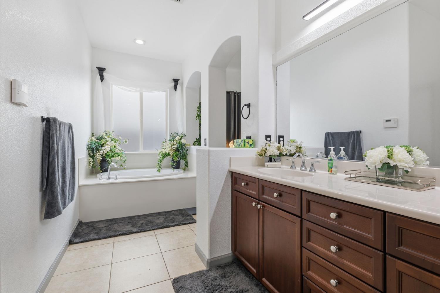 4215 Riopel Avenue Denair, CA 95316 - Photo 24 of 62 a spacious bathroom with a granite countertop sink and a bathtub