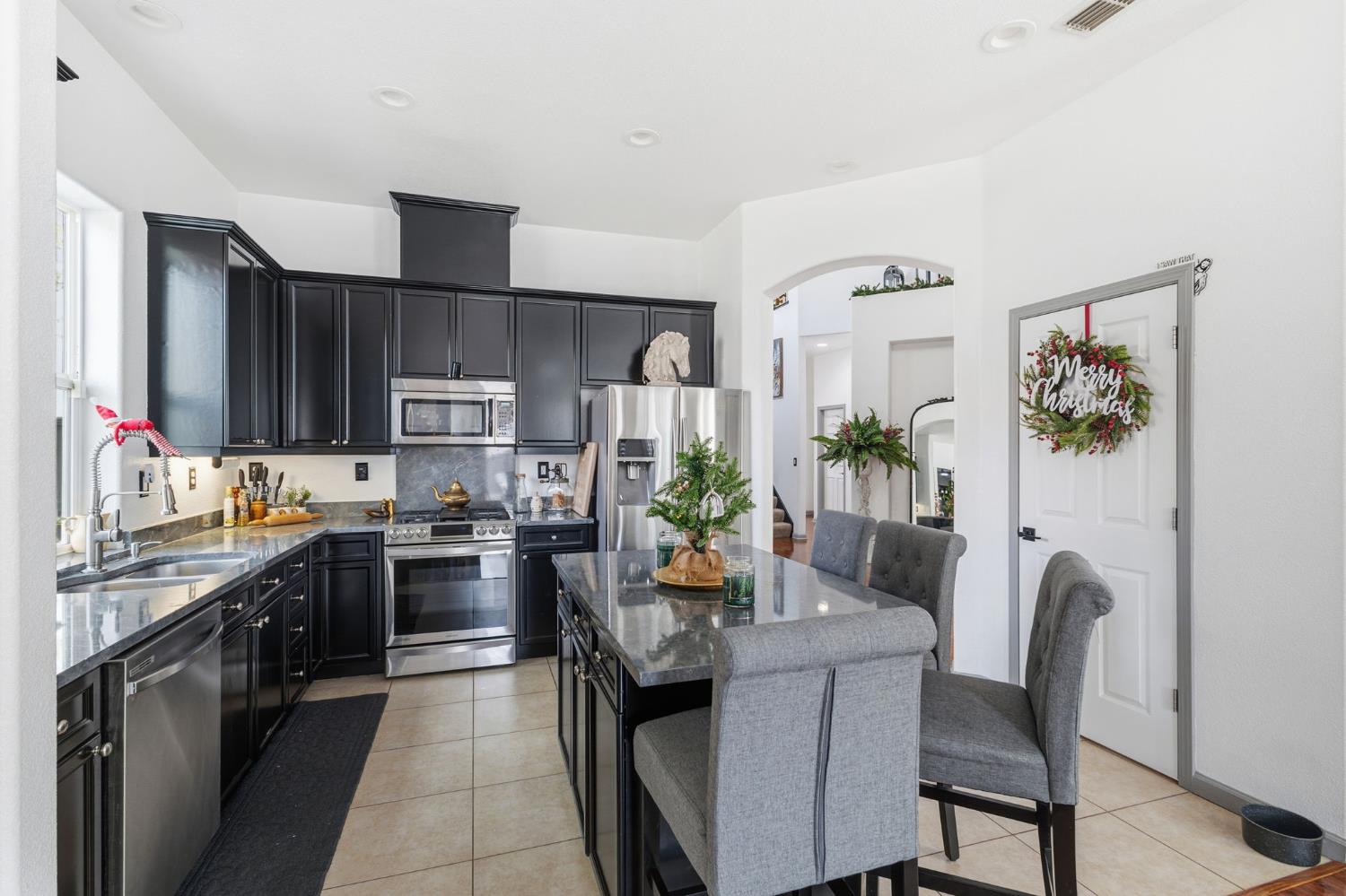 4215 Riopel Avenue Denair, CA 95316 - Photo 10 of 62 a kitchen with stainless steel appliances granite countertop a stove top oven a sink dishwasher a dining table and chairs with wooden floor