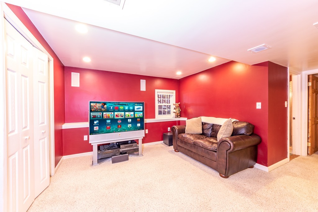 61 Volk Road Dedham, MA 02026 - Photo 23 of 26 a living room with furniture a projector and a flat screen tv