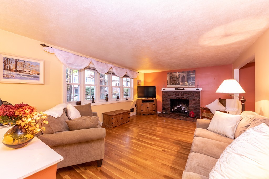 61 Volk Road Dedham, MA 02026 - Photo 3 of 26 a living room with furniture a fireplace and a flat screen tv