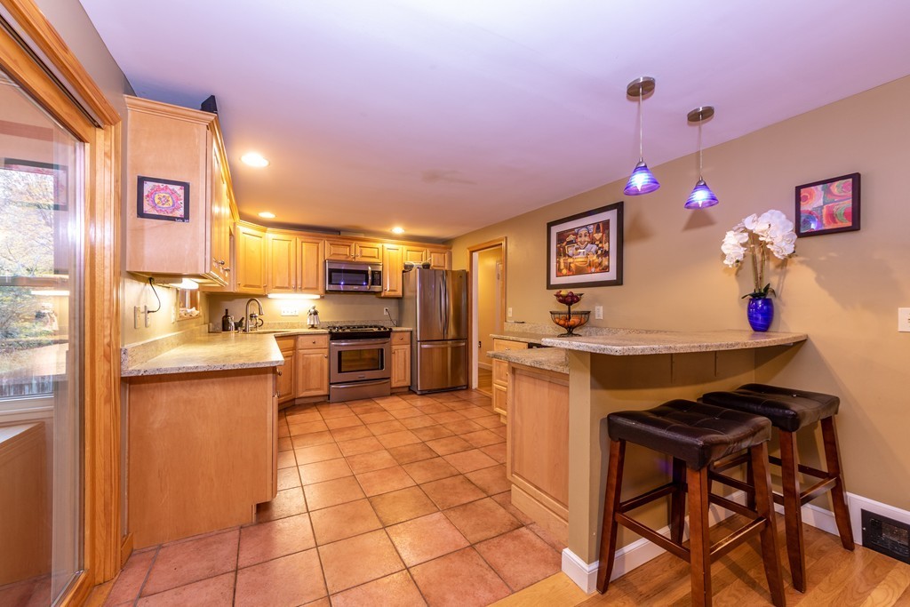 61 Volk Road Dedham, MA 02026 - Photo 8 of 26 a kitchen with granite countertop a sink cabinets and stainless steel appliances