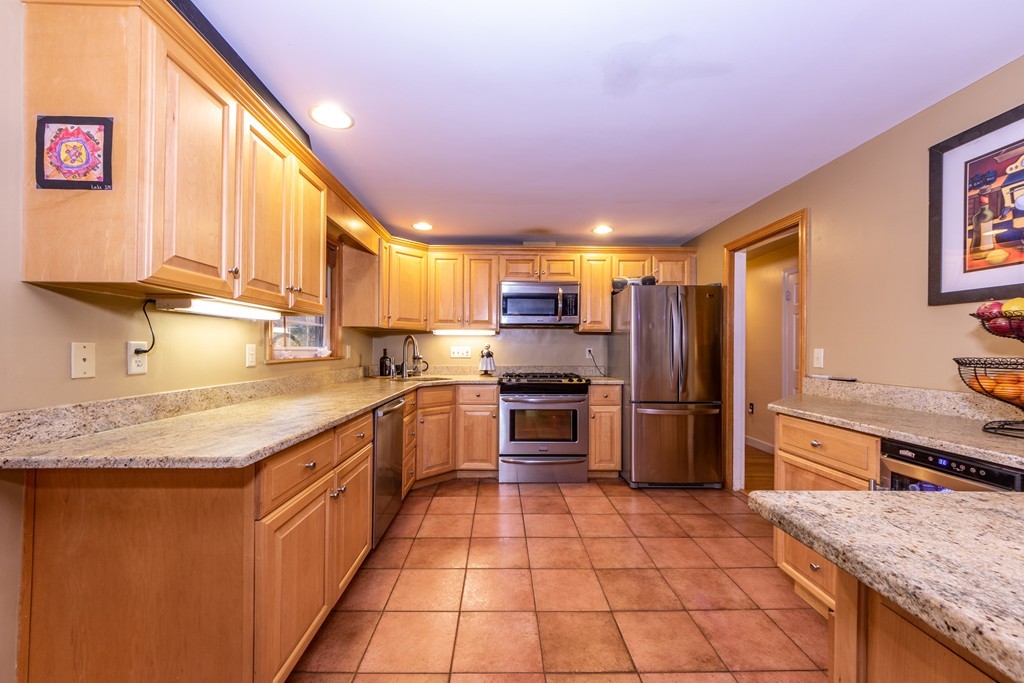 61 Volk Road Dedham, MA 02026 - Photo 10 of 26 a kitchen with stainless steel appliances granite countertop a sink stove and refrigerator