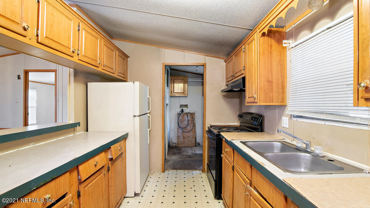 5751 Benedict Road Jacksonville, FL 32209 - Photo 3 of 11 a kitchen with a sink a stove and refrigerator