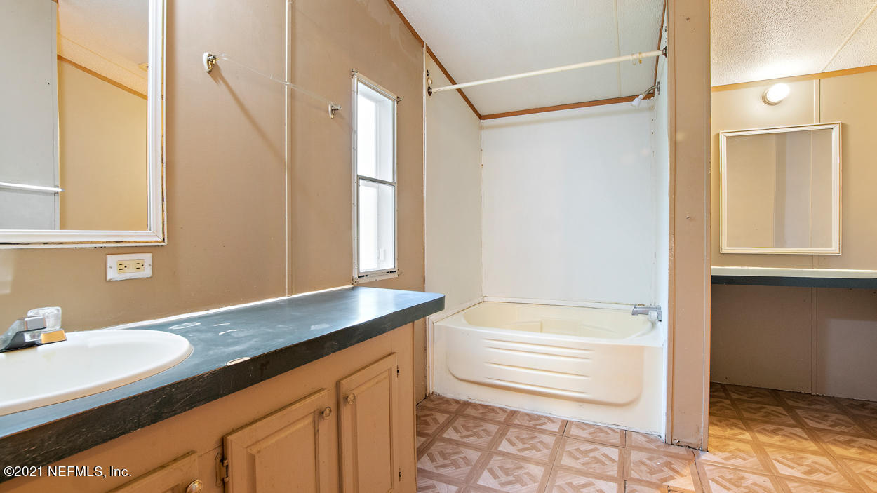 5751 Benedict Road Jacksonville, FL 32209 - Photo 6 of 11 a bathroom with a tub sink and mirror