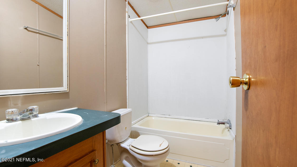5751 Benedict Road Jacksonville, FL 32209 - Photo 8 of 11 a bathroom with a granite countertop sink toilet and shower
