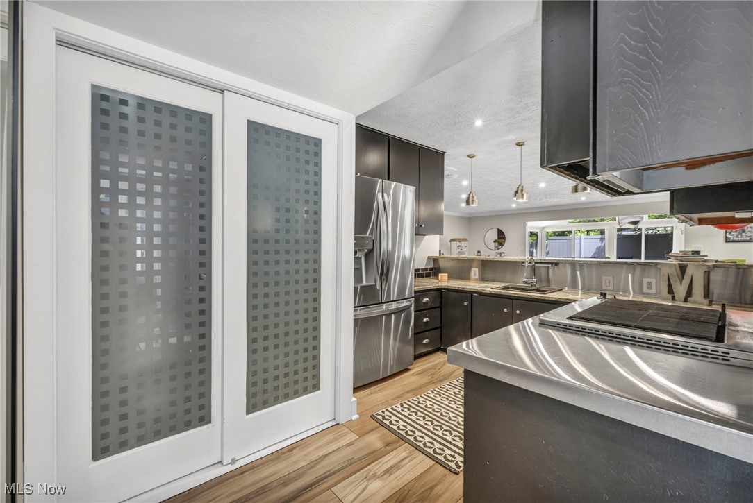 13079 Falling Water Road Strongsville, OH 44136 - Photo 16 of 50 Second kitchen featuring stainless steel refrigerator with ice dispenser, light wood finished floors, pendant lighting, and Granite countertops