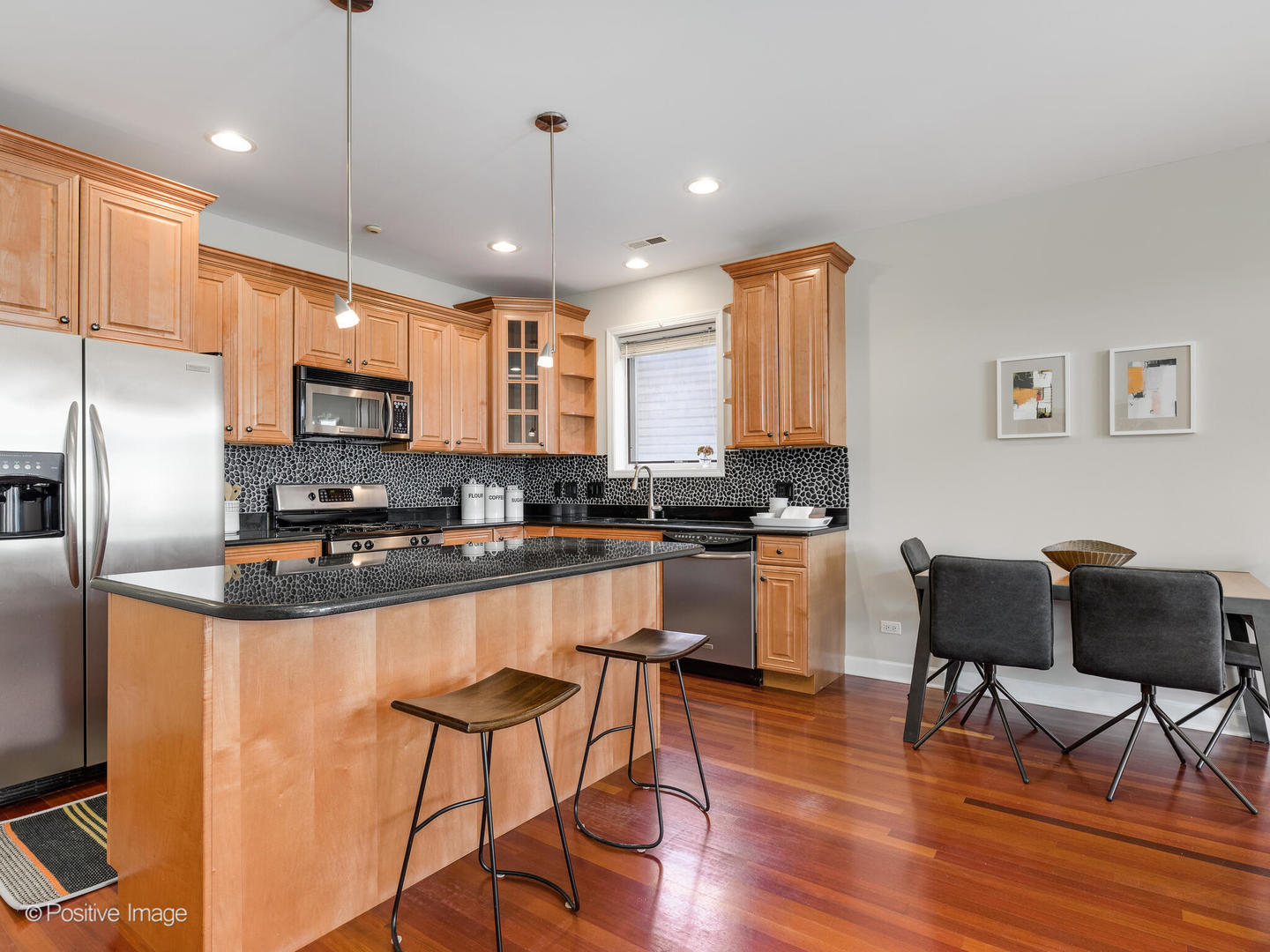 1704 South Morgan Street, Unit 2 Chicago, IL 60608 - Photo 7 of 18 a kitchen with stainless steel appliances granite countertop a stove a refrigerator a sink a stove with island and chairs