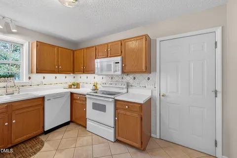 a kitchen with stainless steel appliances granite countertop a refrigerator sink and stove