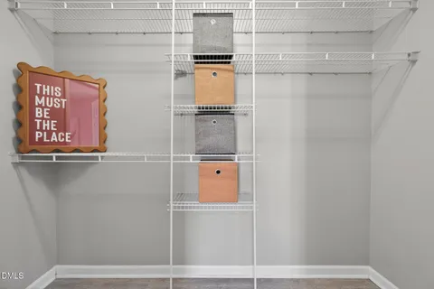 an empty room with wooden floor ceiling fan and windows