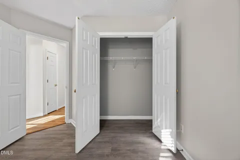 a view of an empty room with window chandelier fan