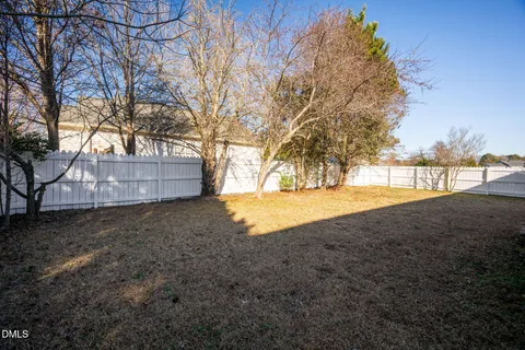 a view of backyard with wooden fence