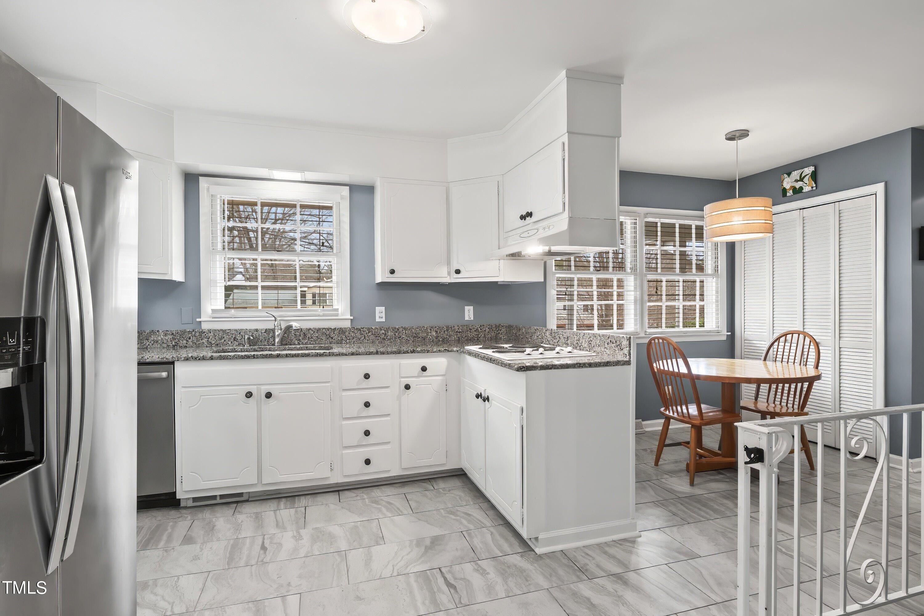 528 Harvard Street Raleigh, NC 27609 - Photo 10 of 44 a kitchen with granite countertop cabinets a window stainless steel appliances and a center island