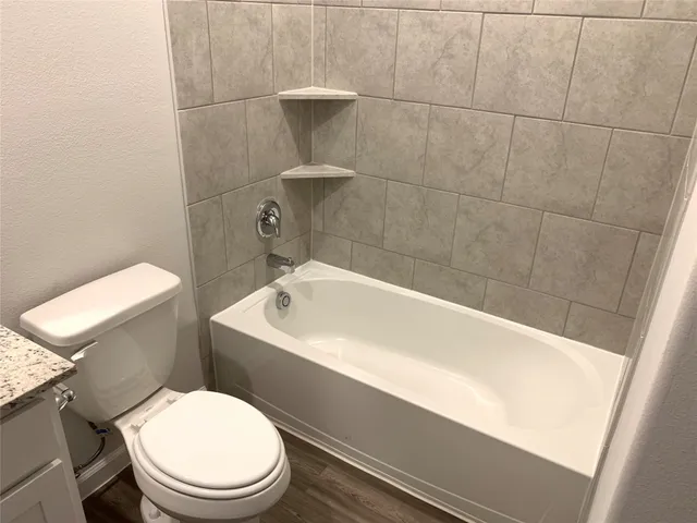a white toilet sitting next to a bath tub