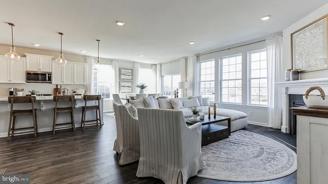 a living room with large couches and kitchen view with wooden floor