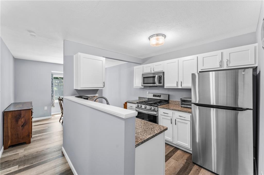 332 Central Drive Cranberry Township, PA 16066 - Photo 3 of 28 a kitchen with stainless steel appliances granite countertop a refrigerator a stove a sink dishwasher and white cabinets with wooden floor