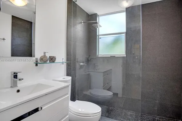 a bathroom with a sink a toilet and shower