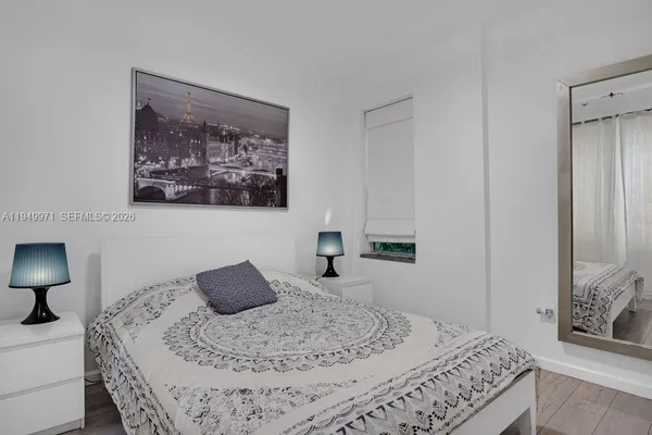 a bedroom with a bed and a painting on the wall