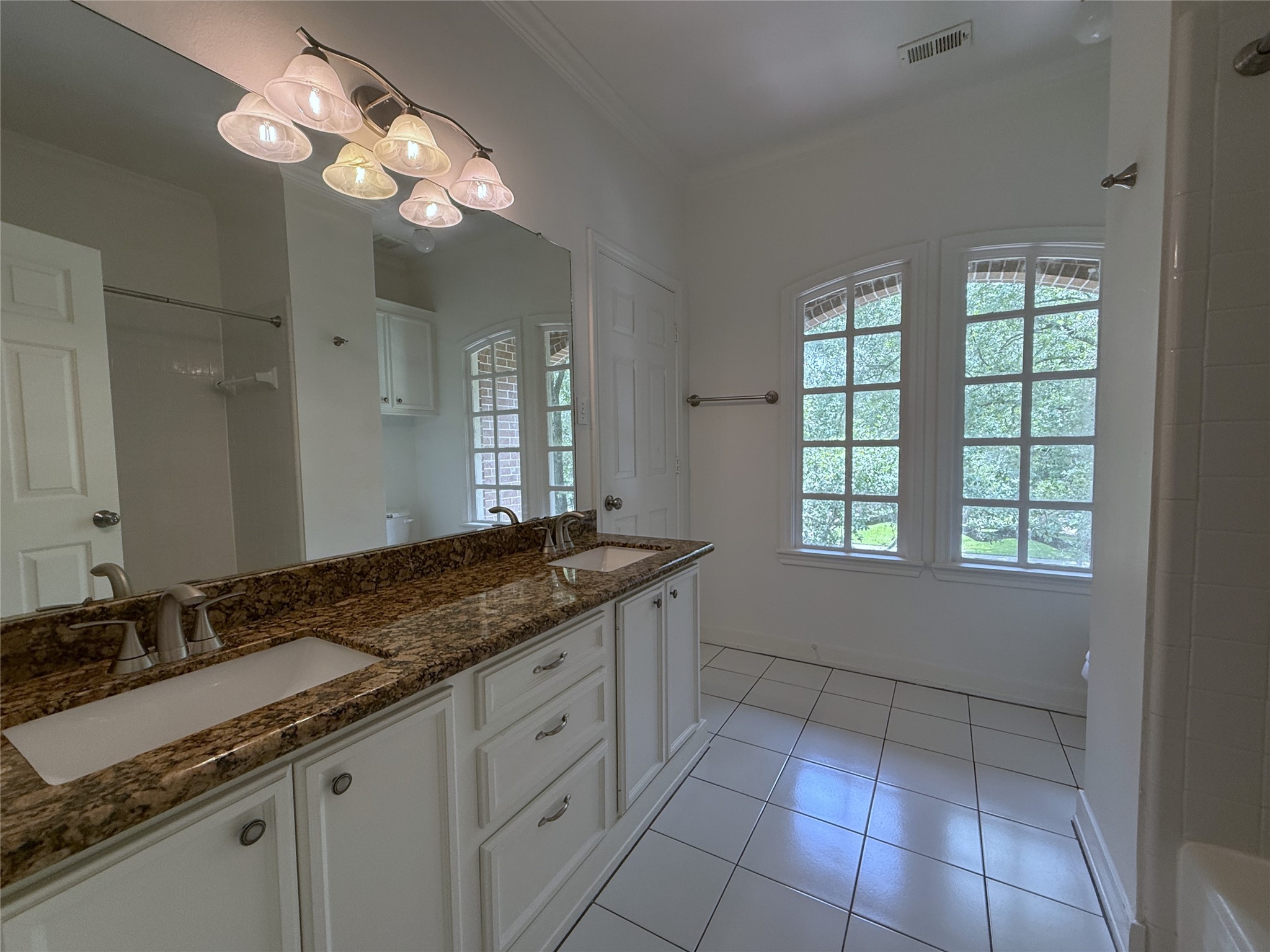 3024 Rice Boulevard Houston, TX 77005 - Photo 28 of 38 With an extended double sink vanity & tub/shower combo, the upstairs hallway bathroom offers a private entry into the second secondary bedroom.