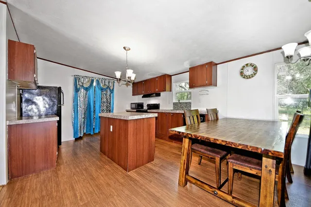 a kitchen with stainless steel appliances granite countertop wooden cabinets a window and a counter space