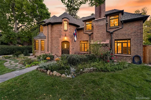 a view of a house with brick walls and a yard with plants