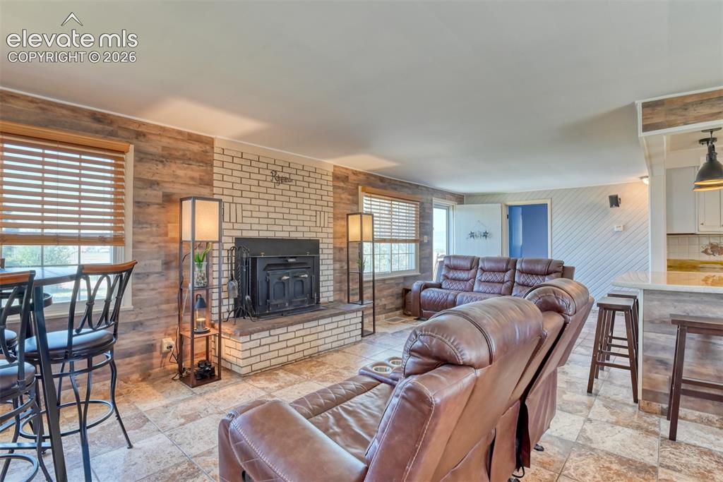 10970 Garrett Road Peyton, CO 80831 - Photo 8 of 50 a living room with furniture a fireplace and a flat screen tv