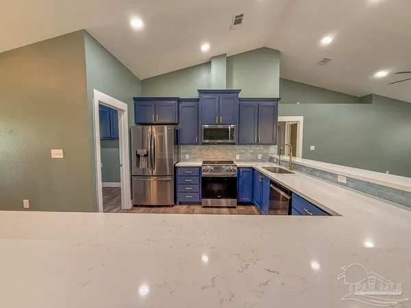 a large kitchen with stainless steel appliances and cabinets