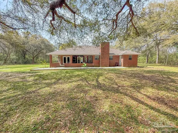 a view of a house with a yard and sitting area