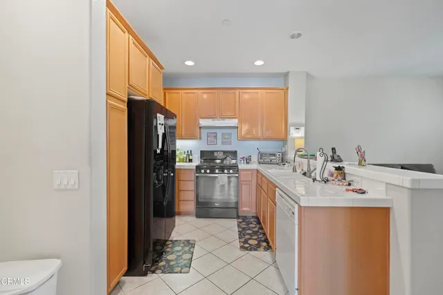 a kitchen with a sink a counter top space and stainless steel appliances