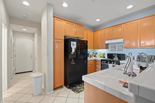 a kitchen with a sink a refrigerator and cabinets