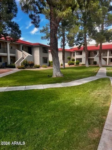 a front view of a house with a garden and trees